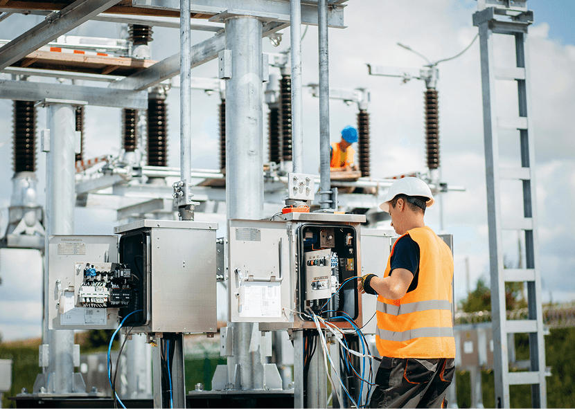 Technician working at electrical substation equipment.