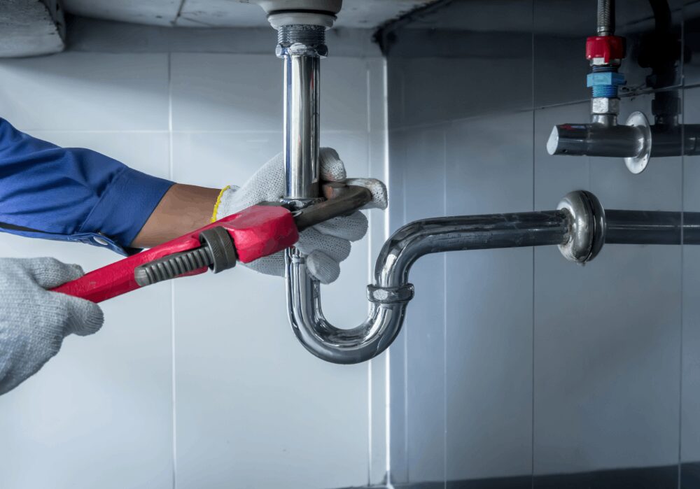 Plumber fixing pipe with adjustable wrench.