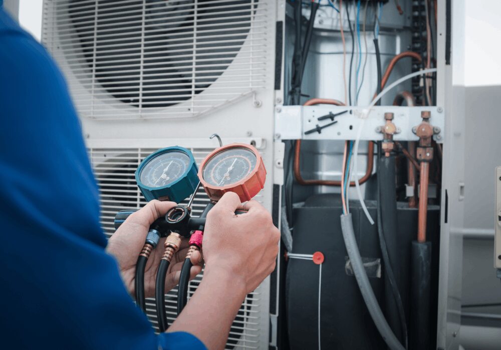 Technician checking HVAC system with gauges.