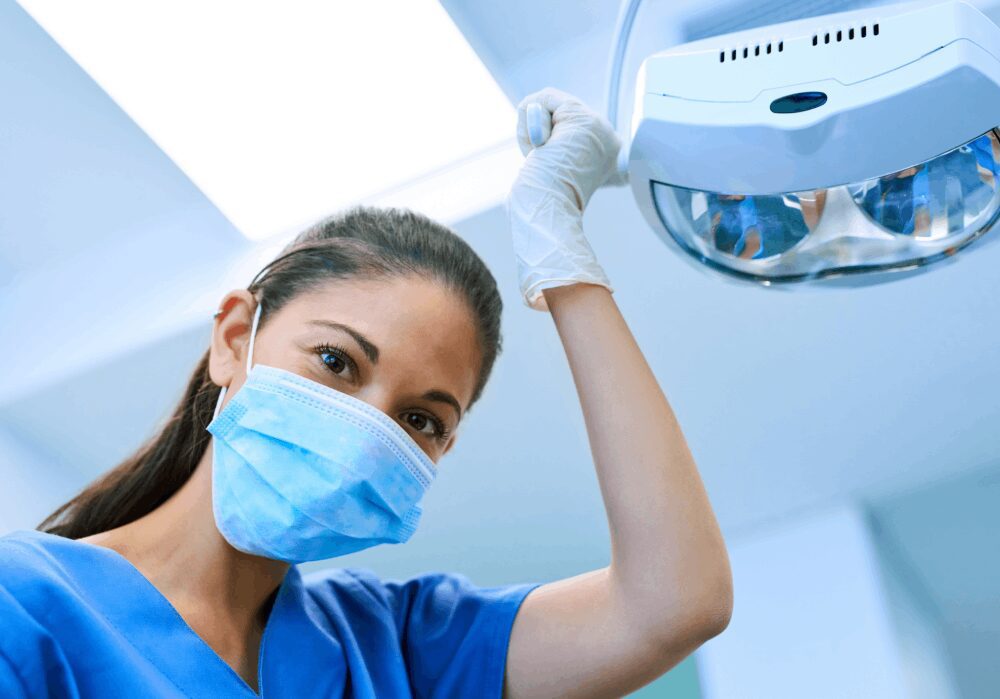 Dentist adjusting overhead light in clinic.