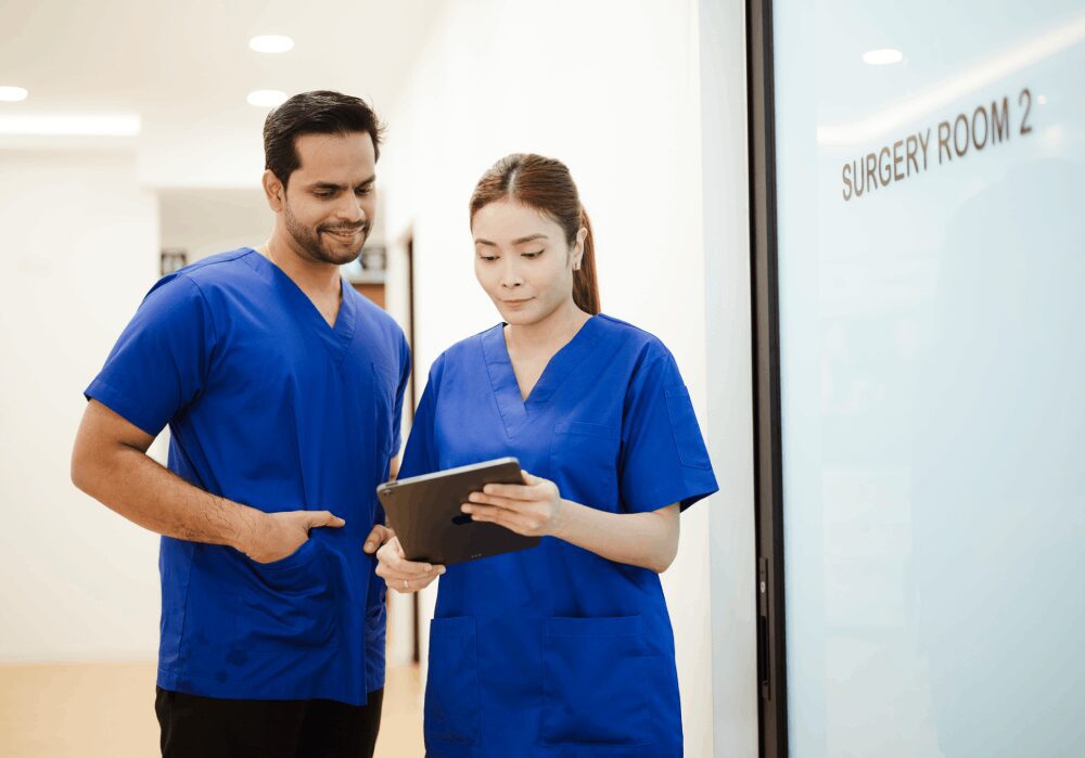 Healthcare professionals reviewing information on tablet.